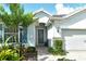 Inviting entryway features a decorative glass door, blue shutters, and professionally landscaped flower beds at 11502 Golden Bay Pl, Bradenton, FL 34211