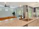 Kitchen island sink featuring granite counters, pendant lights, and views of the living area and backyard patio at 11502 Golden Bay Pl, Bradenton, FL 34211