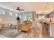 Open-concept living room with wood-look tile flooring, modern ceiling fan, and easy access to the dining room at 11502 Golden Bay Pl, Bradenton, FL 34211