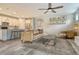 Spacious living room with wood-look tile flooring, open layout, and a view of the modern kitchen at 11502 Golden Bay Pl, Bradenton, FL 34211