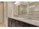 Luxurious main bathroom featuring dual sinks, granite counters, dark wood cabinetry, and a glass door shower at 11502 Golden Bay Pl, Bradenton, FL 34211
