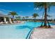 Community pool area with beach entry, surrounded by palm trees and lounge chairs at 11502 Golden Bay Pl, Bradenton, FL 34211