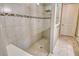Tiled walk-in shower with glass partition and mosaic accent, providing a modern and stylish showering experience at 11502 Golden Bay Pl, Bradenton, FL 34211