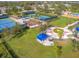 Aerial view of a community park with tennis courts, play areas, and open green spaces for recreation and enjoyment at 11714 Forest Park Cir, Bradenton, FL 34211