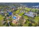Scenic aerial view showcasing community amenities, including playgrounds, tennis courts, and walking paths amidst green spaces at 11714 Forest Park Cir, Bradenton, FL 34211
