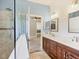 Bathroom features a shower with tile surround, double sinks, and a view into the primary bedroom at 11714 Forest Park Cir, Bradenton, FL 34211