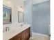 Bathroom featuring double sinks, white countertops, wood cabinets and framed mirrors on the shiplap wall at 11714 Forest Park Cir, Bradenton, FL 34211