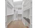 A carpeted walk-in closet with white shelving and hanging rods provides ample storage space at 11714 Forest Park Cir, Bradenton, FL 34211