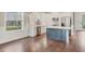 Bright kitchen with white cabinets, a gray island, stainless steel appliances, and wood floors at 11714 Forest Park Cir, Bradenton, FL 34211