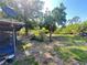 Large backyard with mature trees and a satellite dish visible on the side of the house at 12127 Hunter Ave, Port Charlotte, FL 33953