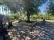 Backyard featuring a large tree with custom planter bed, shed and distant view of a pool at 12127 Hunter Ave, Port Charlotte, FL 33953