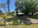Exterior view of the house surrounded by mature trees and lush greenery at 12127 Hunter Ave, Port Charlotte, FL 33953