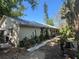 Exterior view of a home with a metal roof and lush landscaping, creating a serene and private setting at 12127 Hunter Ave, Port Charlotte, FL 33953