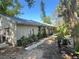 Exterior view of a home with a metal roof, greenery, and gravel, creating a peaceful outdoor area at 12127 Hunter Ave, Port Charlotte, FL 33953
