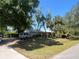 Charming home features lush landscaping, mature trees, and a private drive at 12127 Hunter Ave, Port Charlotte, FL 33953