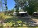Spacious front yard featuring lush green grass and mature trees, creating a tranquil outdoor space at 12127 Hunter Ave, Port Charlotte, FL 33953