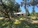 Charming single story house with a metal roof surrounded by mature trees and tropical landscaping at 12127 Hunter Ave, Port Charlotte, FL 33953