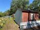 An outbuilding with dual textures, offering a practical space in a large backyard with ladder at 12127 Hunter Ave, Port Charlotte, FL 33953