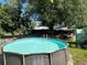 Above ground swimming pool in a backyard with grassy area and foliage creating a private relaxation space at 12127 Hunter Ave, Port Charlotte, FL 33953