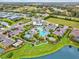 Aerial view of the community clubhouse with an attractive pool, amenities, landscaping and pond at 13849 Old Creek Ct, Parrish, FL 34219
