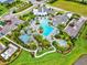 Aerial view of a community pool with palm trees, cabanas and manicured landscaping at 13849 Old Creek Ct, Parrish, FL 34219