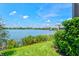 Picturesque lake view from the backyard featuring lush landscaping and blue skies at 13849 Old Creek Ct, Parrish, FL 34219