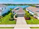 An inviting single-story home boasts lush landscaping, a two-car garage, and beautiful water views at 13849 Old Creek Ct, Parrish, FL 34219
