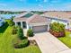 Beautiful single-story home featuring lush landscaping, an attached two-car garage, and scenic water views at 13849 Old Creek Ct, Parrish, FL 34219