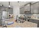 The kitchen has granite countertops, a stainless steel sink, and gray cabinets with modern appliances at 13849 Old Creek Ct, Parrish, FL 34219
