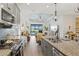 Open concept with gray cabinets, granite counters, stainless appliances, and views of the living area and pool at 13849 Old Creek Ct, Parrish, FL 34219