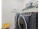 Laundry room featuring front load washer and dryer with window and a wicker basket at 13849 Old Creek Ct, Parrish, FL 34219
