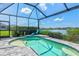 Screened-in pool area with sun shelf, offering a refreshing oasis with picturesque lake views at 13849 Old Creek Ct, Parrish, FL 34219