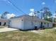 Side exterior of home with a two-car garage and well-maintained lawn at 1422 Jakway Rd, North Port, FL 34288