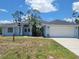 Charming single-story home featuring a two-car garage, manicured lawn, and a welcoming entrance at 1422 Jakway Rd, North Port, FL 34288
