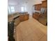 Updated kitchen with stainless steel appliances, light cabinetry, and tile floors at 1422 Jakway Rd, North Port, FL 34288