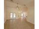 Spacious living room with high ceilings, tile flooring, ceiling fans, and double glass doors at 1422 Jakway Rd, North Port, FL 34288