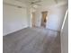 Spacious main bedroom with neutral carpet, tray ceiling, and en suite bathroom entrance at 1422 Jakway Rd, North Port, FL 34288