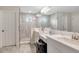 Modern bathroom with double vanity, glass-enclosed shower, and chic gray accents at 14787 Gallop Run Dr, Lithia, FL 33547