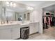 Elegant bathroom featuring double sinks, a large mirror, and a walk-in closet nearby at 14787 Gallop Run Dr, Lithia, FL 33547