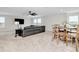Spacious bonus room features neutral carpet, a black leather sectional, and a ceiling fan for comfortable living at 14787 Gallop Run Dr, Lithia, FL 33547