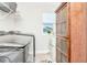Well-equipped laundry room with stainless steel washer and dryer, and charming vintage cabinet at 14787 Gallop Run Dr, Lithia, FL 33547