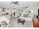 Open-concept living space featuring a staircase, white kitchen, and comfortable seating, designed for modern living at 14787 Gallop Run Dr, Lithia, FL 33547