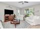 Cozy living room with white sofas, wood-look floors, and sliding glass doors that bring the outdoors in at 14787 Gallop Run Dr, Lithia, FL 33547