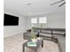 Relax in this contemporary living room with a sleek gray sectional sofa and plush carpeting at 14787 Gallop Run Dr, Lithia, FL 33547