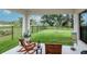 Covered patio with chairs overlooking fenced yard and green space at 14787 Gallop Run Dr, Lithia, FL 33547
