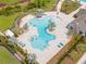Aerial view of a community pool with palm trees, lounge chairs, and a distinctive shape for residents to enjoy at 14787 Gallop Run Dr, Lithia, FL 33547