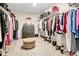 Large walk-in closet with organized shelving, ample hanging space, and a plush ottoman at 14787 Gallop Run Dr, Lithia, FL 33547