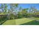 Exterior balcony with artificial turf and black metal railings overlooking tropical greenery at 1607 Flower Dr, Sarasota, FL 34239