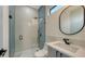 Stylish bathroom featuring a sleek glass-enclosed shower and modern fixtures with a round mirror at 1607 Flower Dr, Sarasota, FL 34239