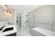Modern bathroom with a double sink vanity, glass shower, and soaking tub with upscale finishes at 1607 Flower Dr, Sarasota, FL 34239